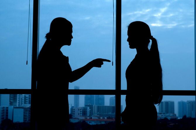 娘を叱責する母親のシルエット