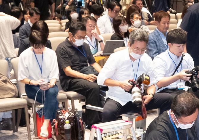 左側、白いトップスの望月記者、右上にチェックのジャケットの石川敏男レポーター。