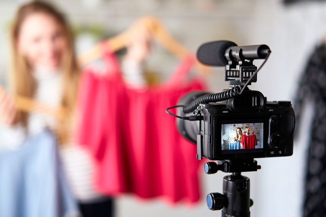Tシャツを手に、動画撮影をしている女性