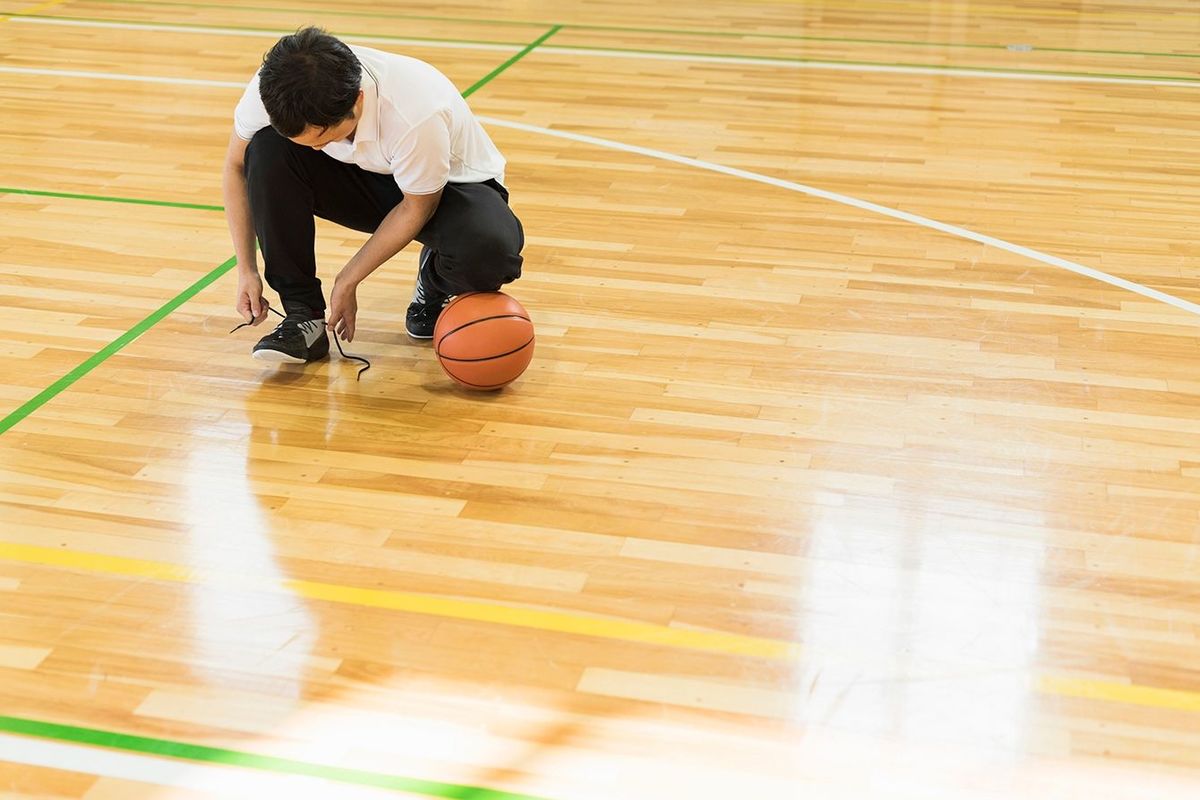 体育館でバスケットボールをしている少年