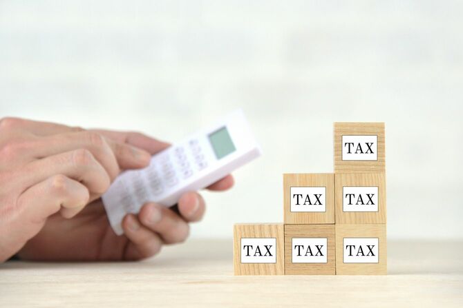 「TAX」と書かれたブロックが積み上げられている、増税のイメージ