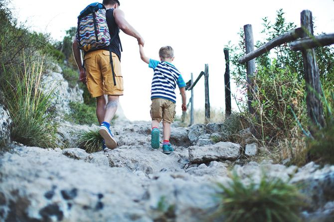 子どもとハイキングをする男性