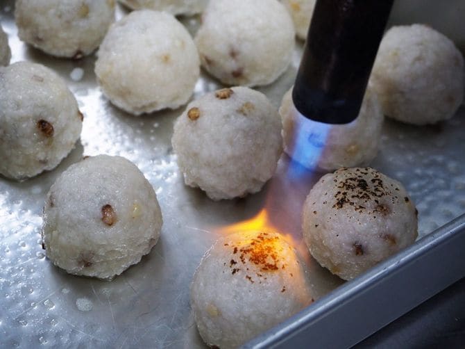 丸めたもち米をバーナーであぶる