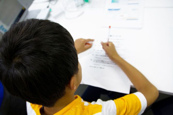 ジャーネーゼの少年は紙に書いています。