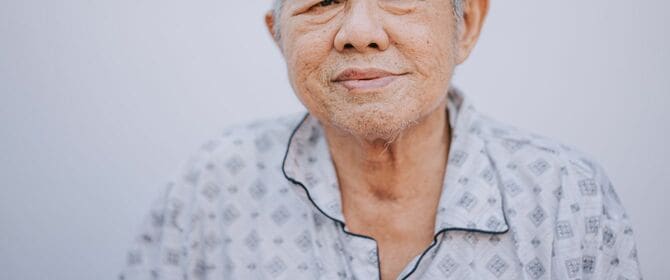 パジャマ着用でカメラを見つめるシニア男性