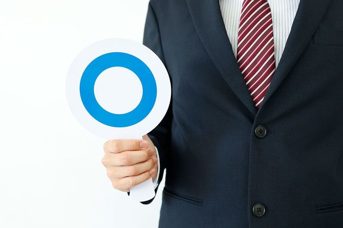 丸の札を持つ人