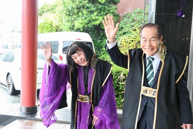 手を振って客を見送る、大女将の宮川高美さん(左)と夫の宮川力さん