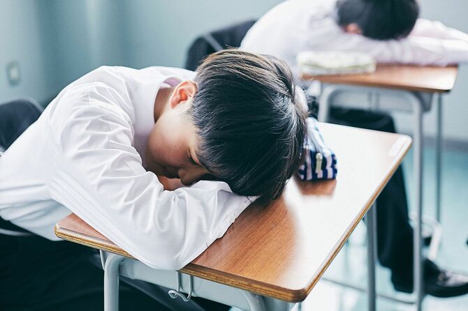 学校の机で寝ている生徒