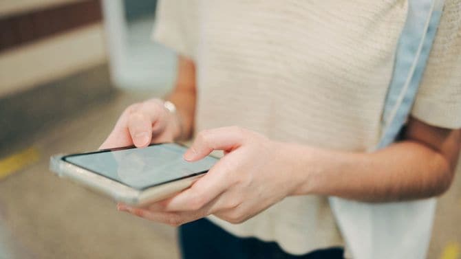 スマホに表示されたマップを頼りに歩く人
