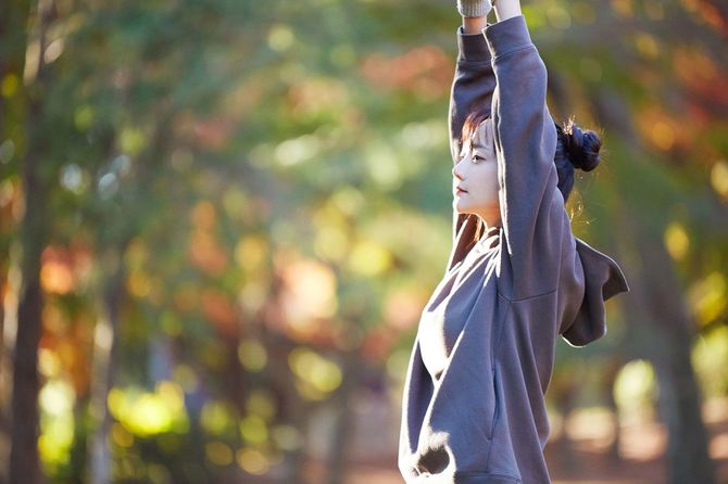 公園で伸びをする女性