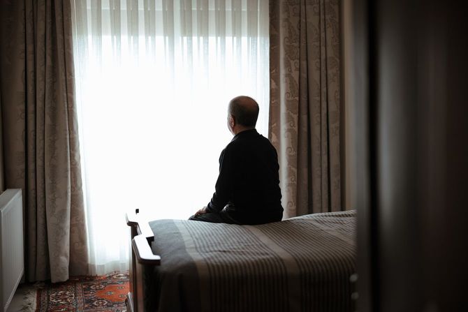 ベッドの上に座っている高齢の男性