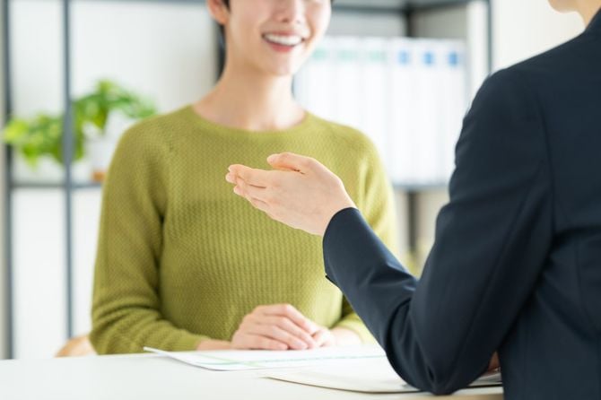 オフィスでビジネスウーマンに相談する若い女性