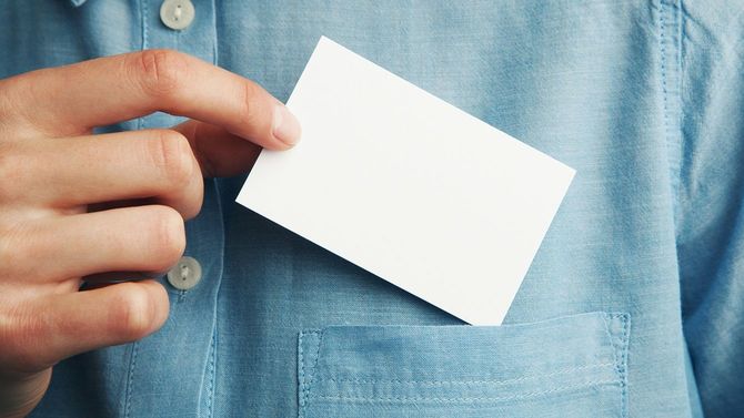 若い男性が空白の名刺をポケットから出す