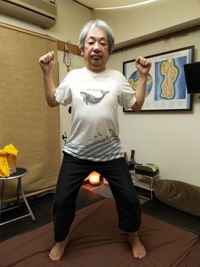 気功立で、軽く拳を握り胸の前