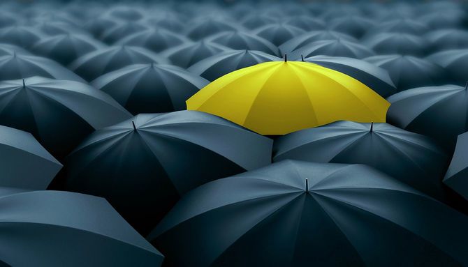 多くの黒い傘の中に一つだけ黄色い傘
