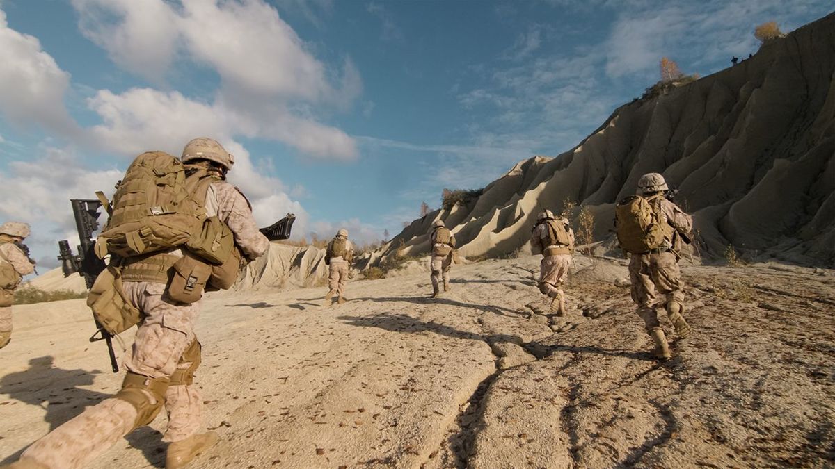 砂漠での軍事作戦中に進むと敵の攻撃を実行している兵士の分隊のショット