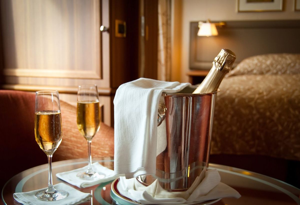高級ホテルの一室に置かれたシャンパンボトルとシャンパンの注がれたグラス