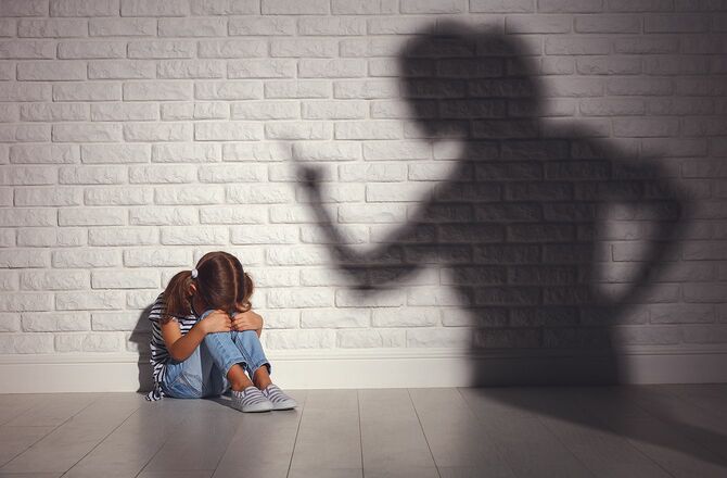 家庭内暴力。怒った母親がおびえる娘を叱る