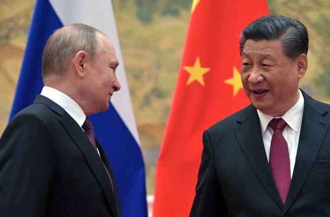 2022年2月4日、北京で、記念撮影に応じる中国の習近平国家主席（右）とロシアのプーチン大統領