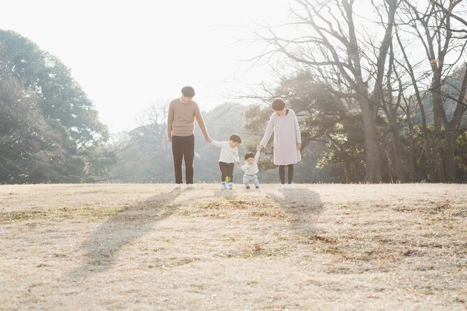 公園で散歩をする夫婦と子ども