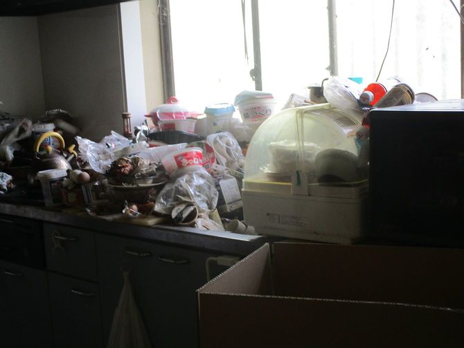 80代女性宅のキッチン。カップ麺などが積み上がっていて、流しを使うことはできない。