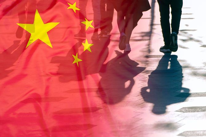 通りを歩く人たちと中国の国旗