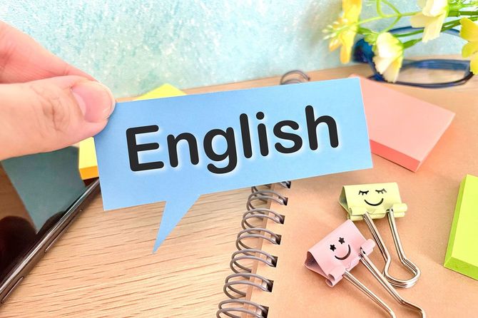 「English」と書かれた吹き出しを持つ人の手