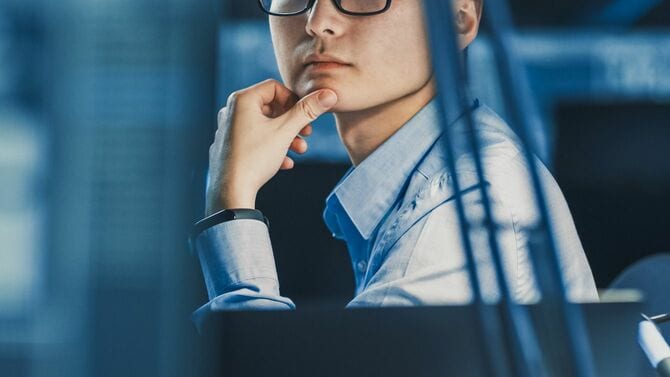 コンピューターに囲まれて考える技術者