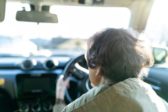 車を運転するシニア女性