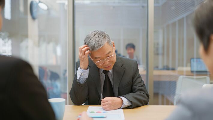 頭を悩ませる高齢ビジネスマン