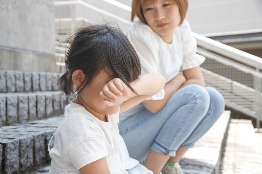 泣いている女の子に寄り添う母親