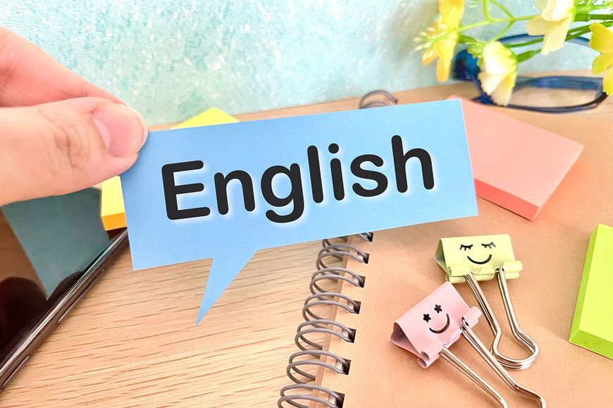 「English」と書かれた吹き出しを持つ人の手