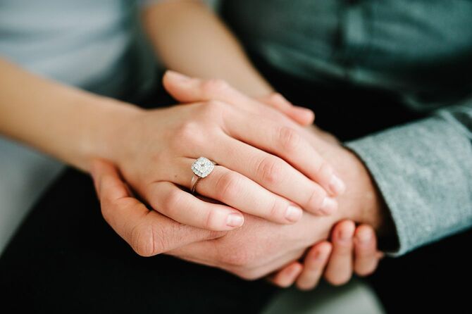 女性の指には大ぶりなダイアモンドのついた婚約指輪