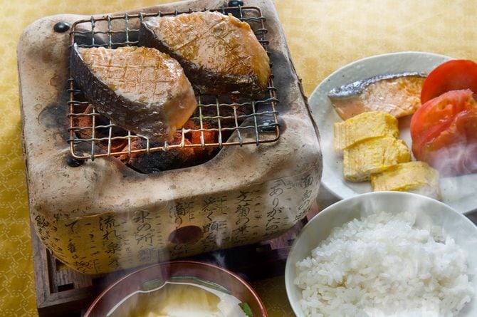 炭火で焼いている魚が付いた、豪華な朝ごはん