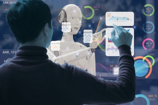未来的なデータ画面を操作する人と人型AIロボット