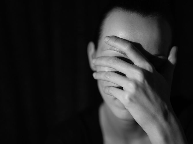 右手で顔を覆っている女性