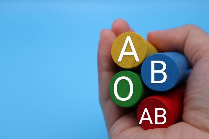 ABOABと書かれたブロックを持つ手