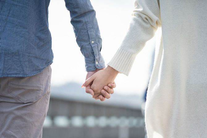 手をつないで歩くカップル