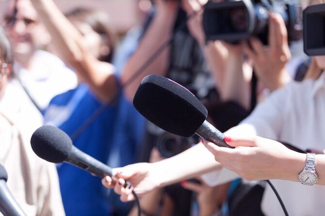 マイクを向ける記者