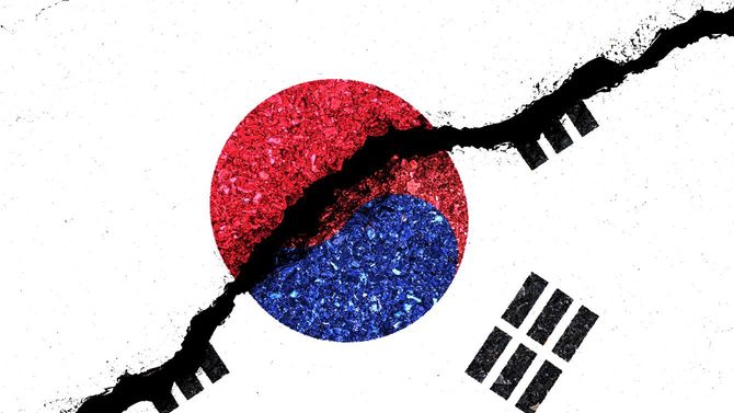 亀裂の入った壁に描かれた日章旗と、韓国の国旗