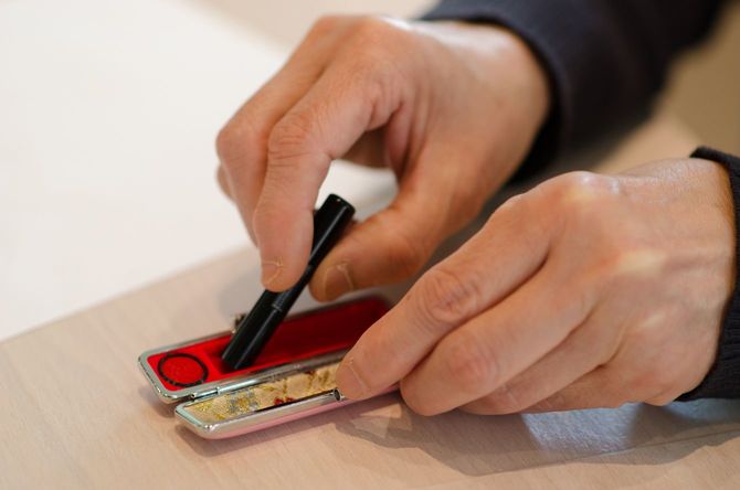 印鑑をケースにしまう手元