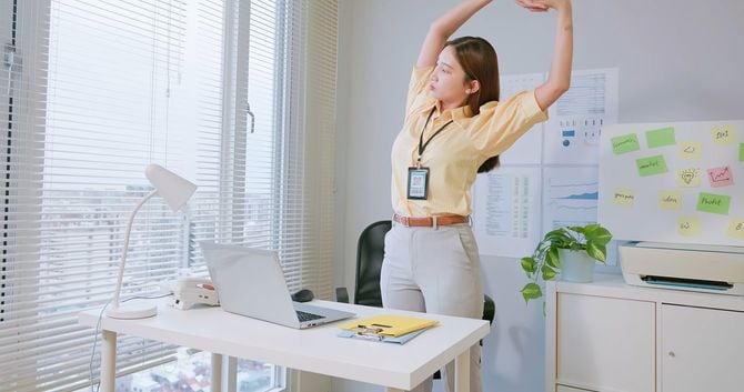 オフィスでストレッチする女性
