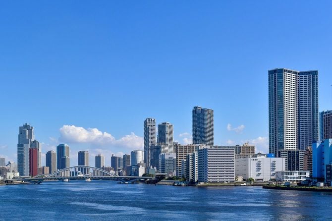 青い空と青い海の間に建物と橋が架かる東京湾の眺め