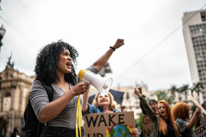 メガホンを使ったデモを主導する若い女性