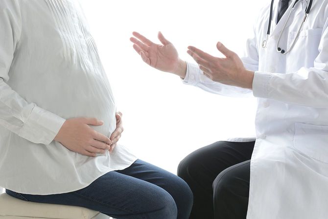 妊娠中の女性と病院の医師