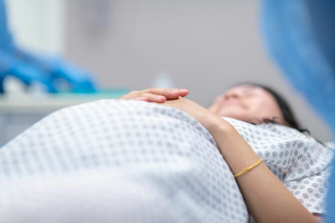 帝王切開のため、手術台に横たわる妊婦