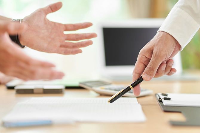 説明に反論するシニア男性の手元