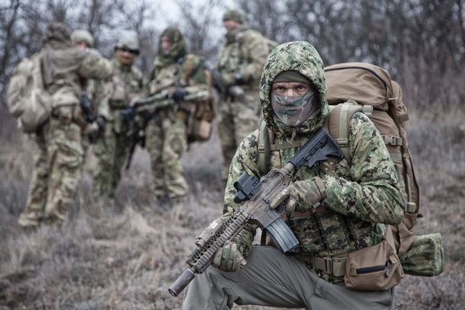 迷彩柄のジャケットのフードを着用した兵士たち