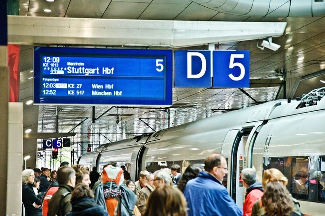 ドイツの鉄道駅のホームで高速列車の乗車を待つ人々
