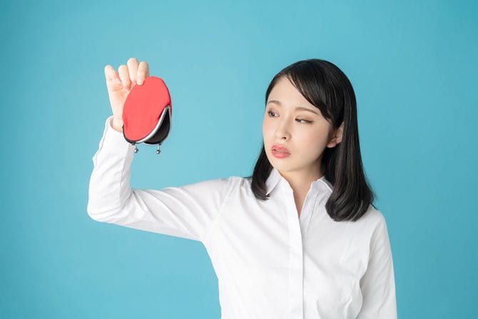 小銭入れをひっくり返す女性